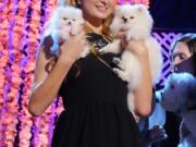 Paris Hilton, accompanied by her Pomeranian dogs, Prince Hilton, right, and her newest pup, Princess Paris Jr., poses for pictures after the taping of the 2015 World Dog Awards Saturday in Santa Monica, Calif.