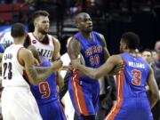 Detroit Pistons forward Shawne Williams, right, is held back by teammate Joel Anthony after an altercation with Portland Trail Blazers forward Joel Freeland, second from left, on Friday.