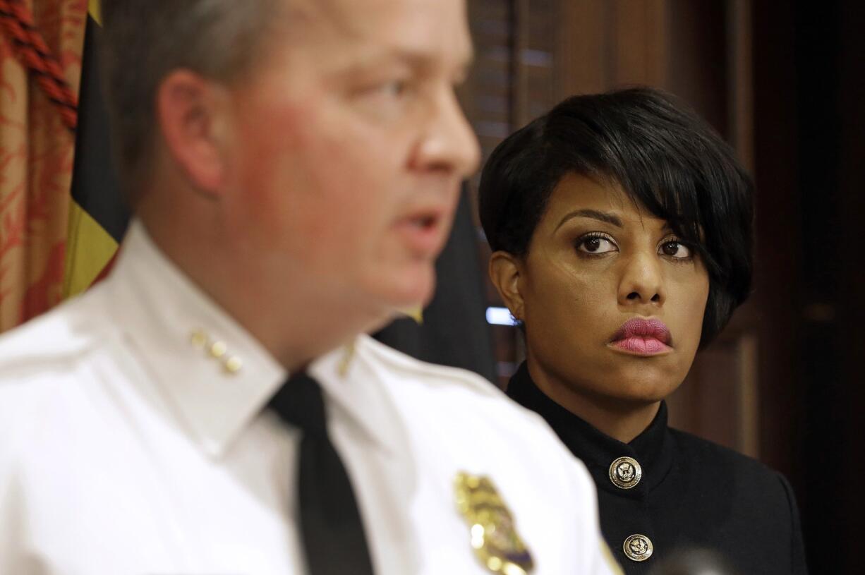 Baltimore Mayor Stephanie Rawlings-Blake, right, listens as Interim Baltimore Police Department Commissioner Kevin Davis speaks at a news conference Wednesday in Baltimore, after Rawlings-Blake announced her firing of Commissioner Anthony Batts.