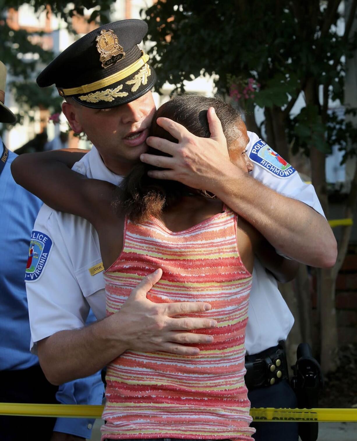 Richmond Deputy Police Chief Steve Drew hugs a lady at the scene of a shooting involving a police officer in Richmond, Va., on Wednesday.