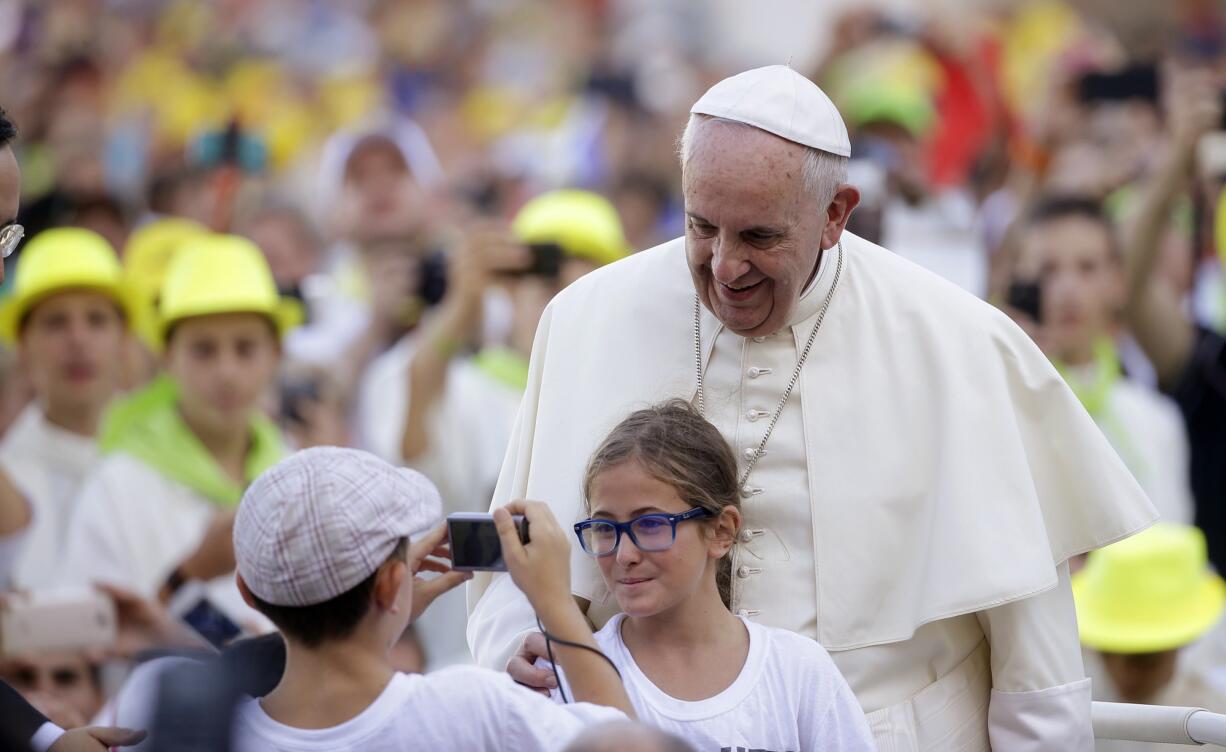 Associated Press files
Pope Francis poses for a photo this month as he arrives in St. Peter's Square at the Vatican for an audience with altar boys and girls. Democrats and Republicans are looking forward to Francis' remarks to Congress next month.