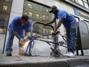 City workers remove an abandoned bike from a rack Thursday in Philadelphia.