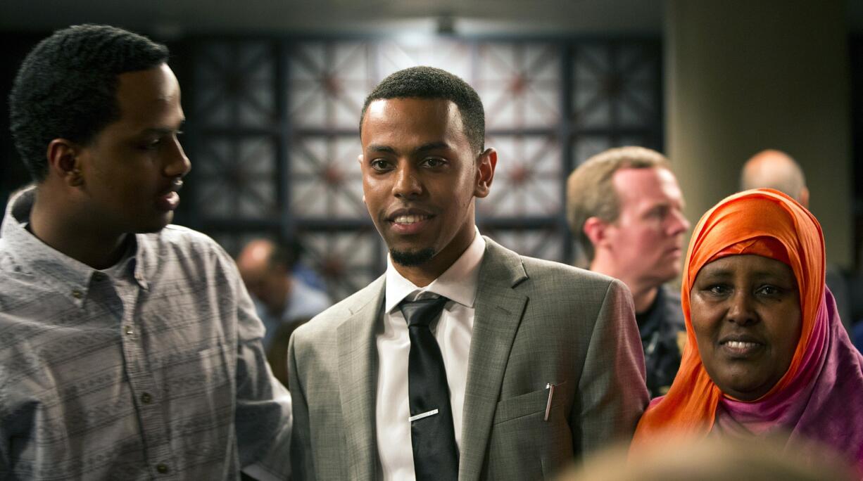 Khalid Ibrahim, center, mingles with family members, including his mom, Fadumo Mohamed, right, after being sworn in as Portland's first Somali-American police officer on Thursday, May 28, 2015.