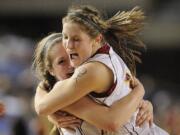 Prairie's Angela Gelhar, left, celebrates with teammate Cori Woodward after the Falcons beat Kamiakin High School in their Class 3A state semifinal game on Friday at the Tacoma Dome.