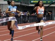 Allyson Felix, left, hits the tape ahead of Sanya Richards-Ross to win the 400-meter race during the Prefontaine Classic track and field meet in Eugene, Ore., Saturday, May 30, 2015.