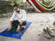 Omar Akersim, 26, a leader among gay Muslims, sits on his prayer rug Friday at his home in Los Angeles.