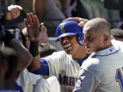 Seattle Mariners' Nelson Cruz, center, is congratulated after his home run by Kyle Seager (15) and teammates against the Texas Rangers in the sixth inning Sunday, Aug. 9, 2015, in Seattle. The Mariners won 4-2.