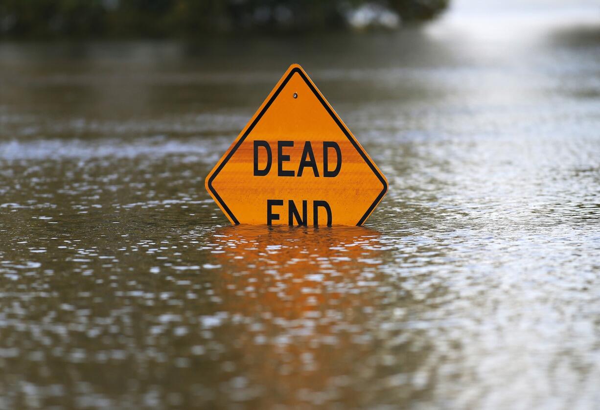 A sign is partially submerged,  caused by flooding from the Red River on Friday, June 12, 2015, in Bossier City, La.