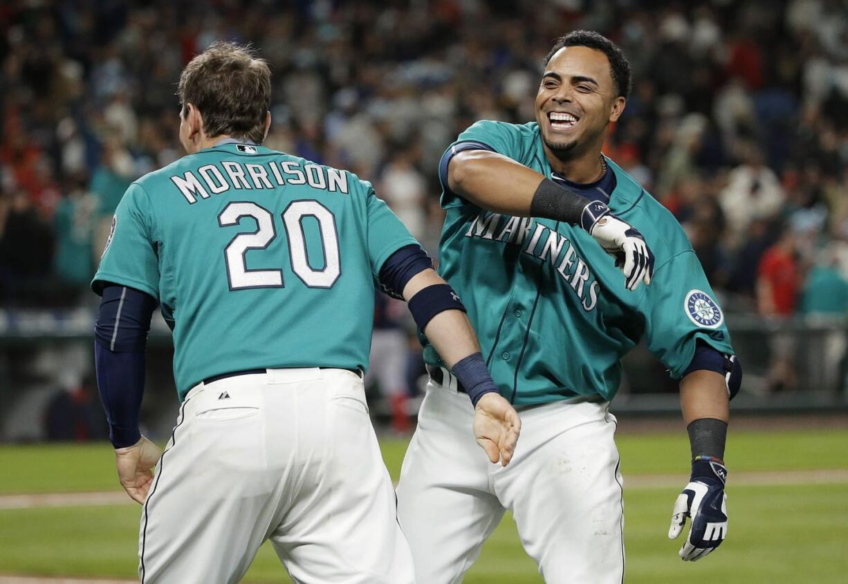 Seattle Mariners' Nelson Cruz, right, celebrates his walk-off RBI single with teammate Logan Morrison in the ninth inning against Boston Red Sox, Friday, May 15, 2015, in Seattle. The Mariners won 2-1. (AP Photo/Ted S.