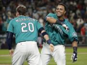 Seattle Mariners' Nelson Cruz, right, celebrates his walk-off RBI single with teammate Logan Morrison in the ninth inning against Boston Red Sox, Friday, May 15, 2015, in Seattle. The Mariners won 2-1. (AP Photo/Ted S.