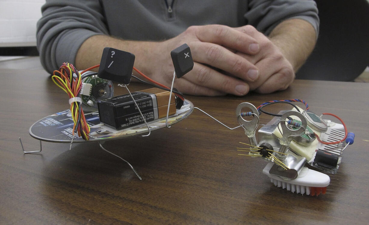 Two small robots made from a CD, toothbrush bristles and motors are displayed at the Reuseum, a technology education and recycling center in Boise, Idaho.