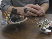 Two small robots made from a CD, toothbrush bristles and motors are displayed at the Reuseum, a technology education and recycling center in Boise, Idaho.