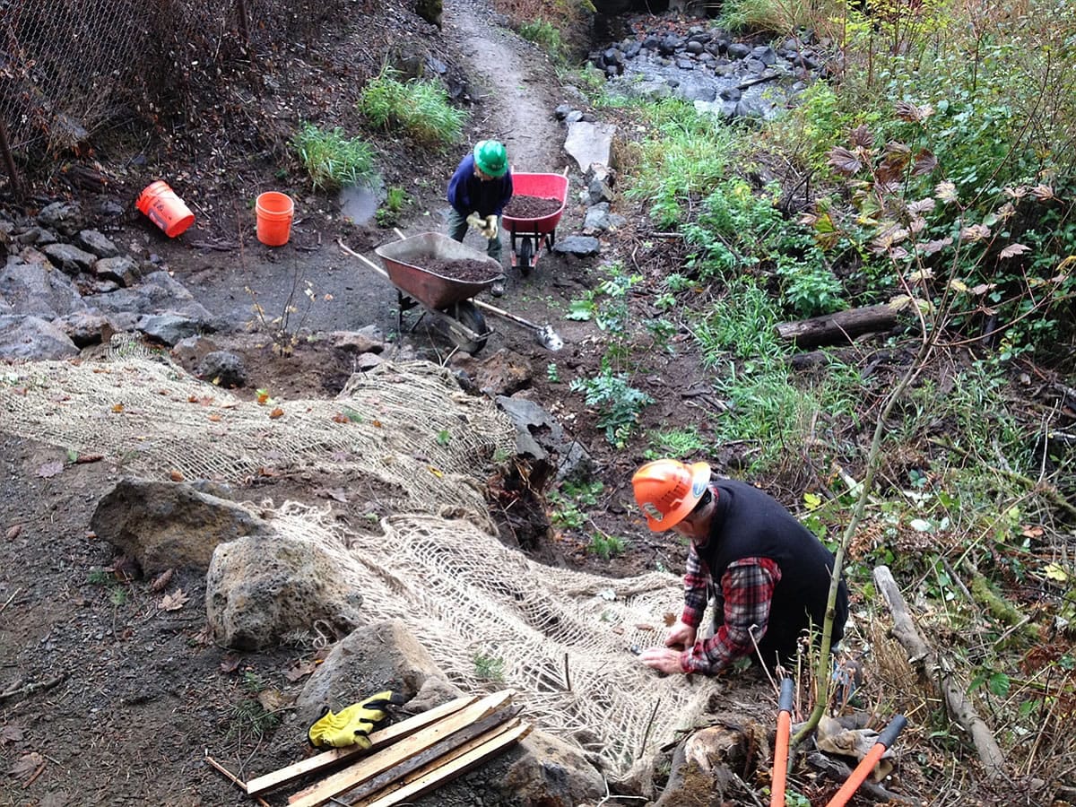 Ryan Ojerio/Washington Trails Association 
  
 Washington Trails Association volunteers build up the slope for the River to Rock Trail, a new connector path that links the day-use area to the trail to the top of Beacon Rock State Park.