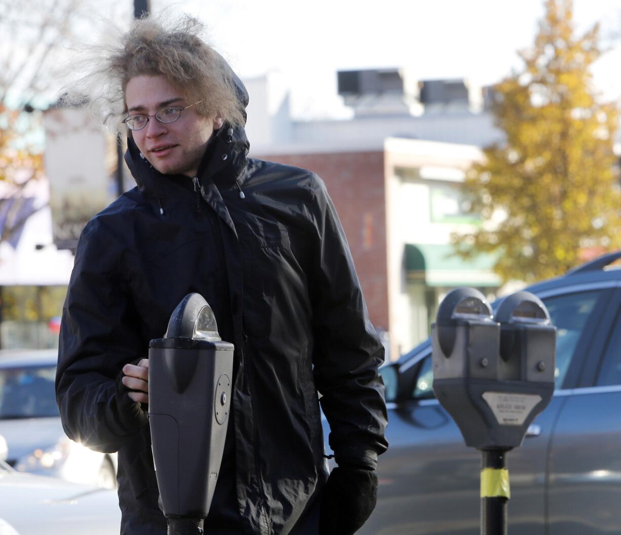 JIM COLE/Associated Press
Garret Ean, one of many self-proclaimed &quot;Robin Hooders,&quot; puts money in an expired meter ahead of parking enforcement officers on Wednesday in Keene, N.H. The band of activists stalks parking enforcement officers, pumping expired meters before the officers can write tickets.