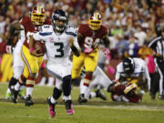 Seattle Seahawks quarterback Russell Wilson (3) scrambles with the ball during the second half of an NFL football game against the Washington Redskins in Landover, Md.