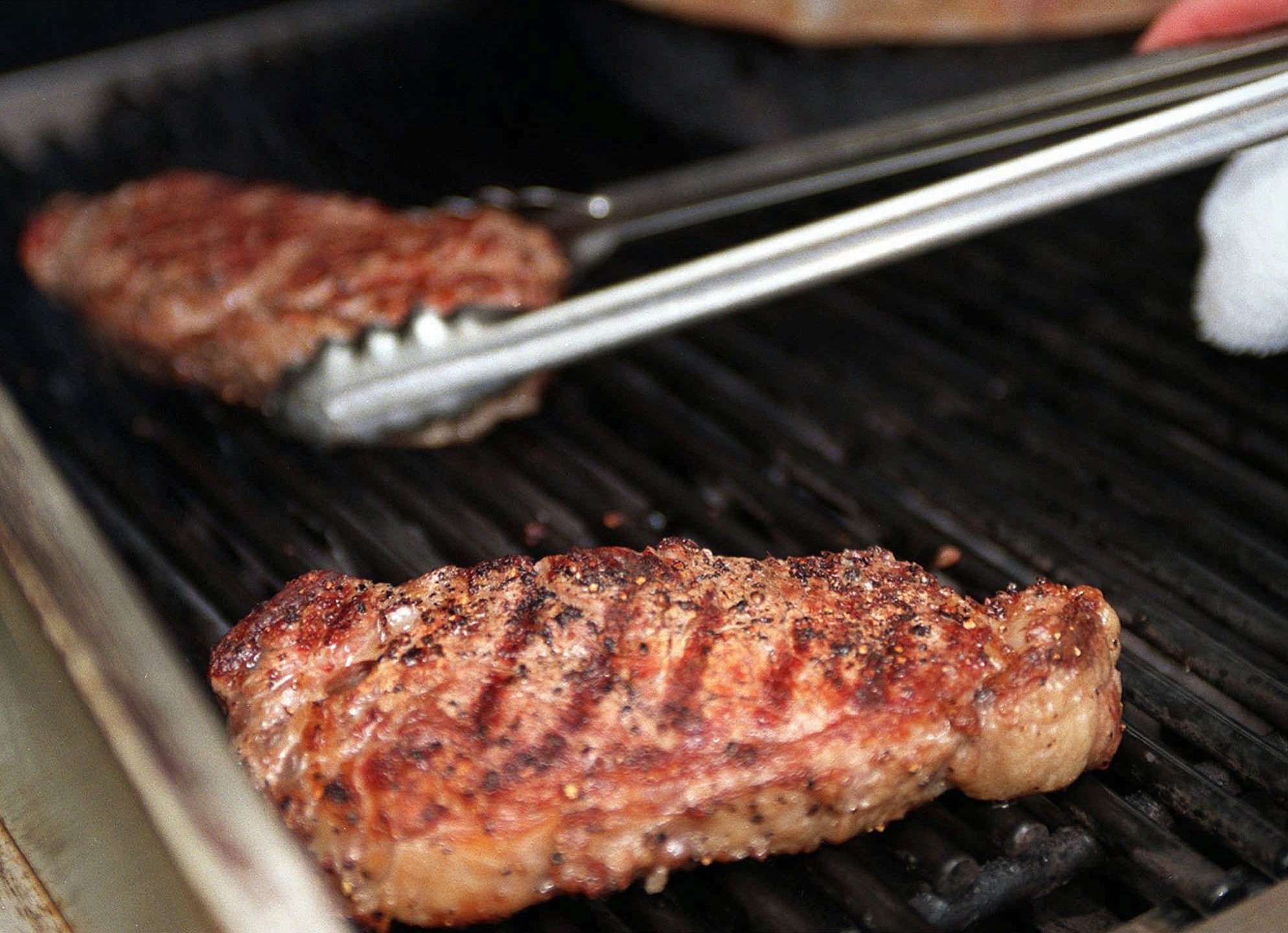 Making a steakhouse-quality steak is easy on the backyard grill. One restaurant owner suggests searing the steak in a skillet before putting on the grill to seal in the flavor and also -- spice liberally.