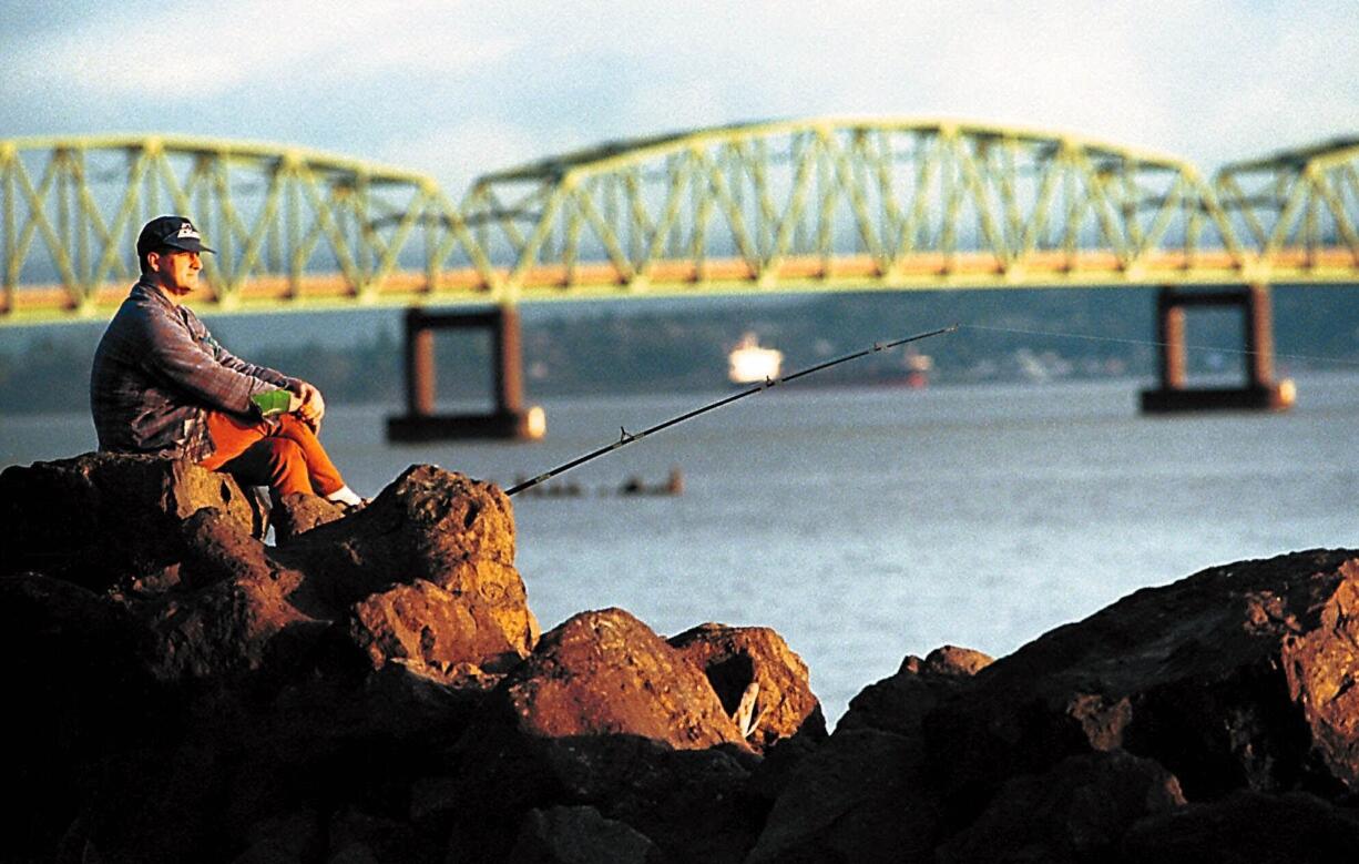 A sportsman waits patiently for a bite while sturgeon fishing in the Columbia River estuary near Chinook, Wash.