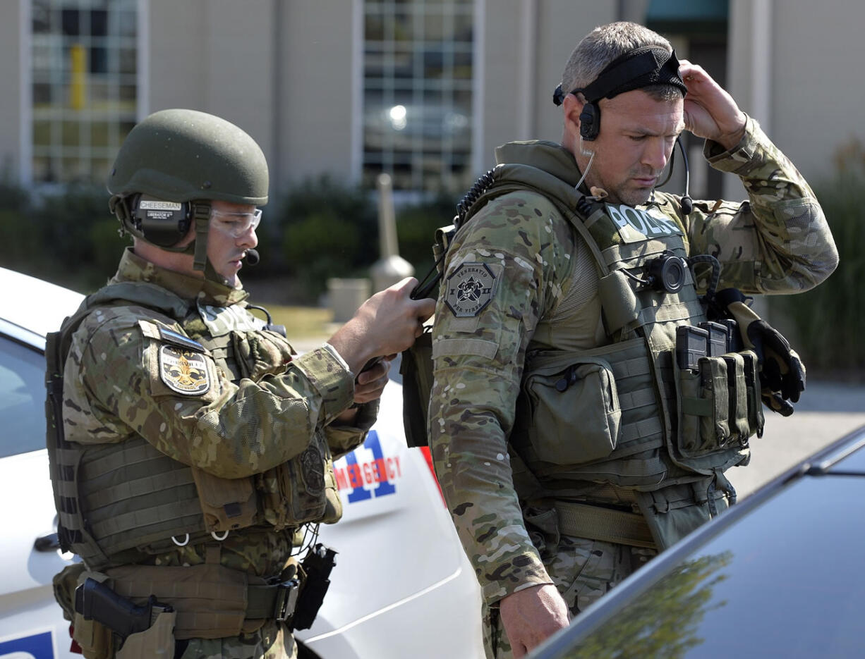 Members of the Louisville SWAT team prepare to enter Fern Creek High School to do a sweep Tuesday, Sept. 30, 2014 at Fern Creek High School in Louisville, Ky. One child was injured and a high school was evacuated after a report of weapons seen on the campus in Louisville, police said Tuesday. Spokeswoman Alicia Smiley says the child sustained non-life threatening injuries and that a parent was with the child. (AP Photo/Timothy D.