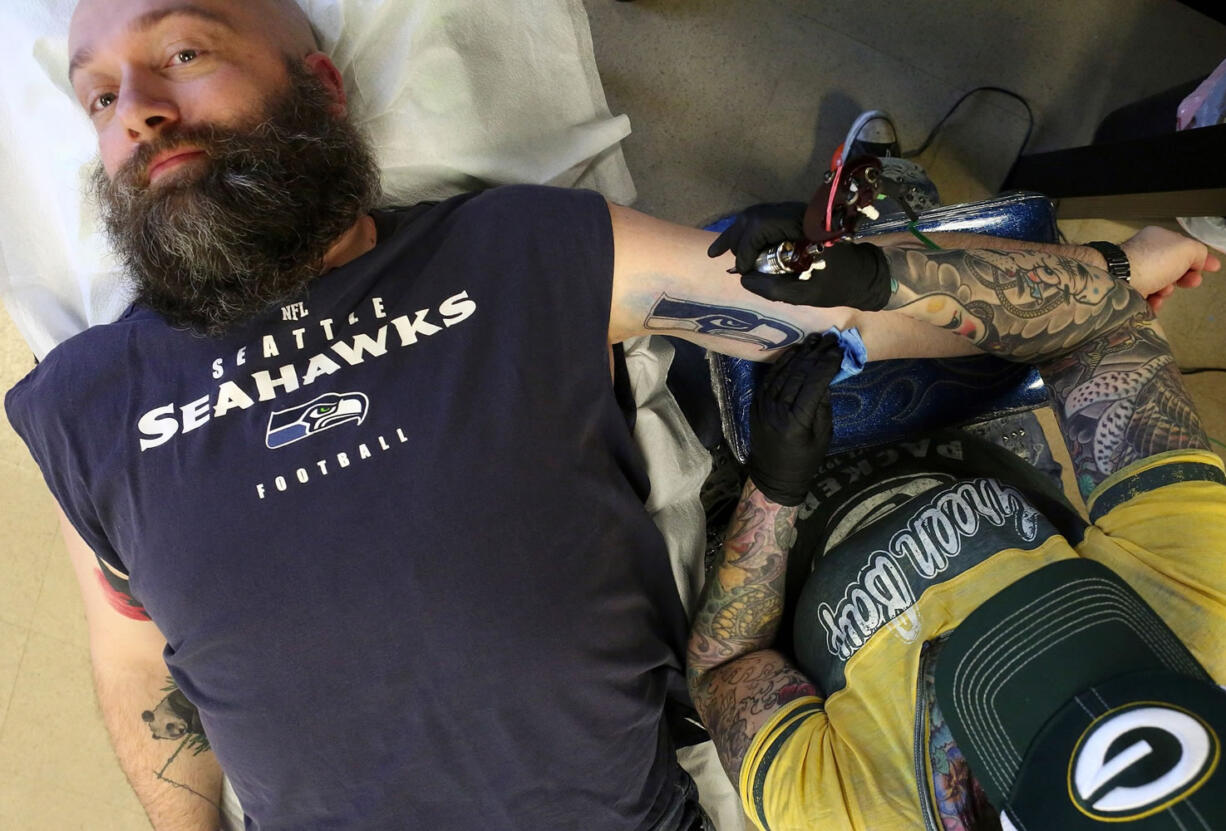 Jason Estep of Everett gets a Seahawks tattoo from Erika Jones of 522 Tattoo in Lake Forest Park.