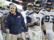 Seattle Seahawks head coach Pete Carroll, left, and quarterback Russell Wilson (3) celebrate during the fourth quarter against the San Francisco 49ers in Santa Clara, Calif., Thursday, Nov. 27, 2014.