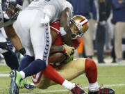 Seattle Seahawks strong safety Kam Chancellor, left, tackles San Francisco 49ers wide receiver Michael Crabtree during the first quarter on Thursday, Nov. 27, 2014.