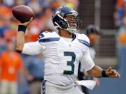 Seattle Seahawks quarterback Russell Wilson (3) throws against the Denver Broncos during the first half of an NFL preseason football game, Thursday, Aug. 7, 2014, in Denver.