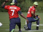 Seattle Seahawks quarterback Russell Wilson, right, and backup quarterback Tavaris Jackson, left, stretch Thursday, Aug. 13, 2015, during training camp in Renton. The Seahawks will play the Denver Broncos Friday in a preseason game in Seattle. (AP Photo/Ted S.