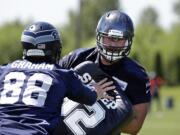 Seattle Seahawks' Jesse Davis, right, runs through a drill with Jimmy Graham (88) during an NFL football organized team activity on Tuesday, June 9, 2015, in Renton.