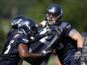 Seattle Seahawks' Justin Britt, right, is pushed back during a drill at training camp practice on Saturday, July 26, 2014, in Renton.