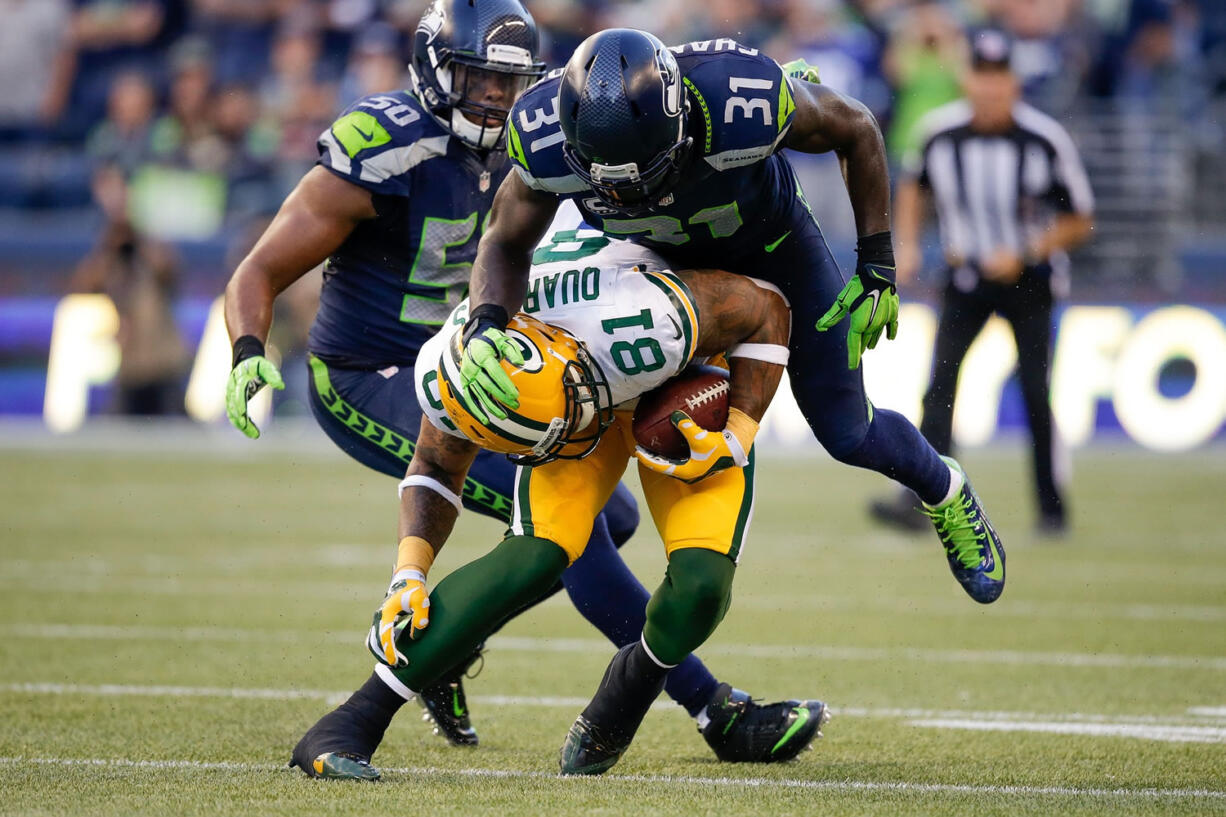 Seattle Seahawk's safety Kam Chancellor (31) tackles Green Bay Packers tight end Andrew Quarless after a reception in the second quarter of an NFL football game between the Seattle Seahawks and the Green Bay Packers, Thursday, Sept. 4, 2014, in Seattle.