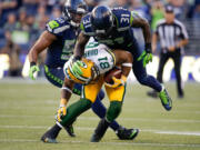 Seattle Seahawk's safety Kam Chancellor (31) tackles Green Bay Packers tight end Andrew Quarless after a reception in the second quarter of an NFL football game between the Seattle Seahawks and the Green Bay Packers, Thursday, Sept. 4, 2014, in Seattle.