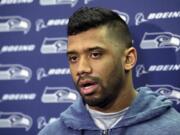 Seattle Seahawks quarterback Russell Wilson talks to reporters outside the locker room at team headquarters, Tuesday, Feb. 3, 2015, in Renton. Signing the QB to a new contract is one of issues the team needs to address in the offseason. (AP Photo/Ted S.