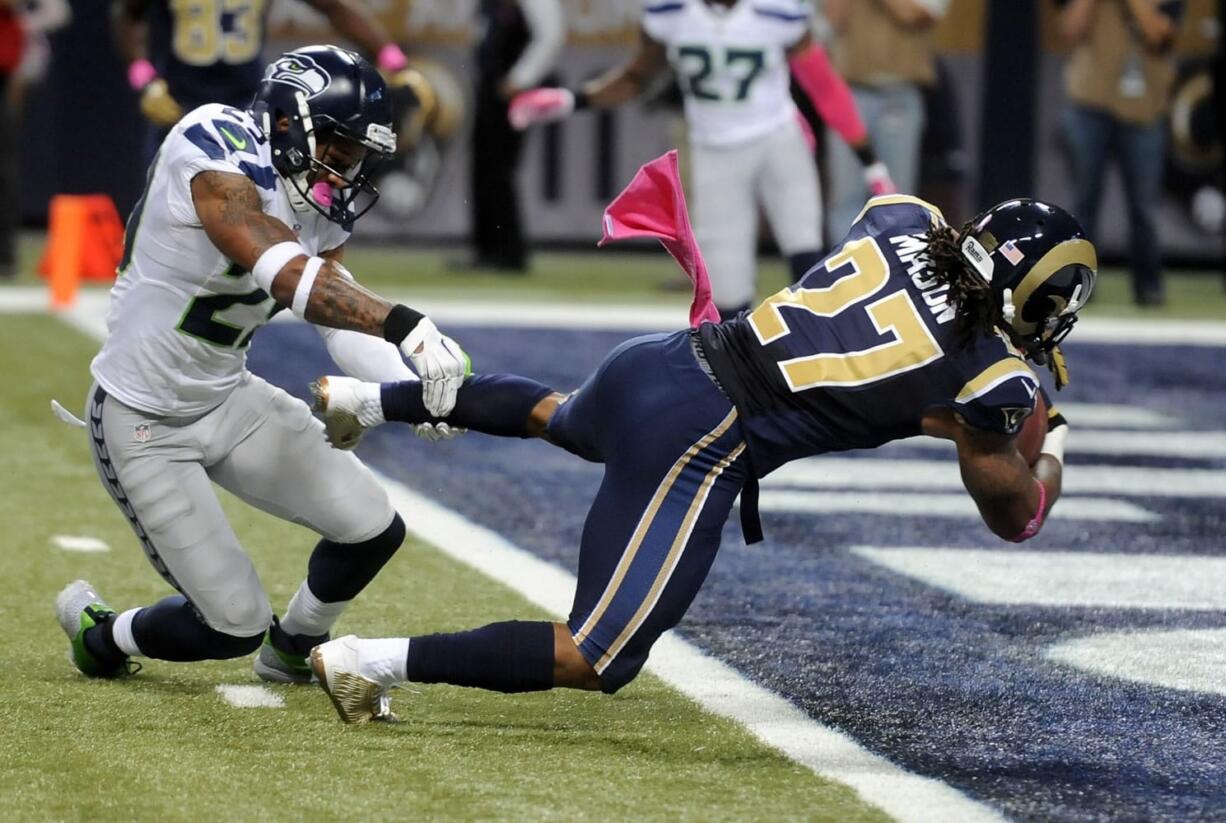 St. Louis Rams running back Tre Mason, right, slips past Seattle Seahawks free safety Earl Thomas on his way to a 6-yard touchdown run during the first quarter Sunday, Oct. 19, 2014, in St. Louis. (AP Photo/L.G.