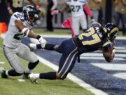 St. Louis Rams running back Tre Mason, right, slips past Seattle Seahawks free safety Earl Thomas on his way to a 6-yard touchdown run during the first quarter Sunday, Oct. 19, 2014, in St. Louis. (AP Photo/L.G.