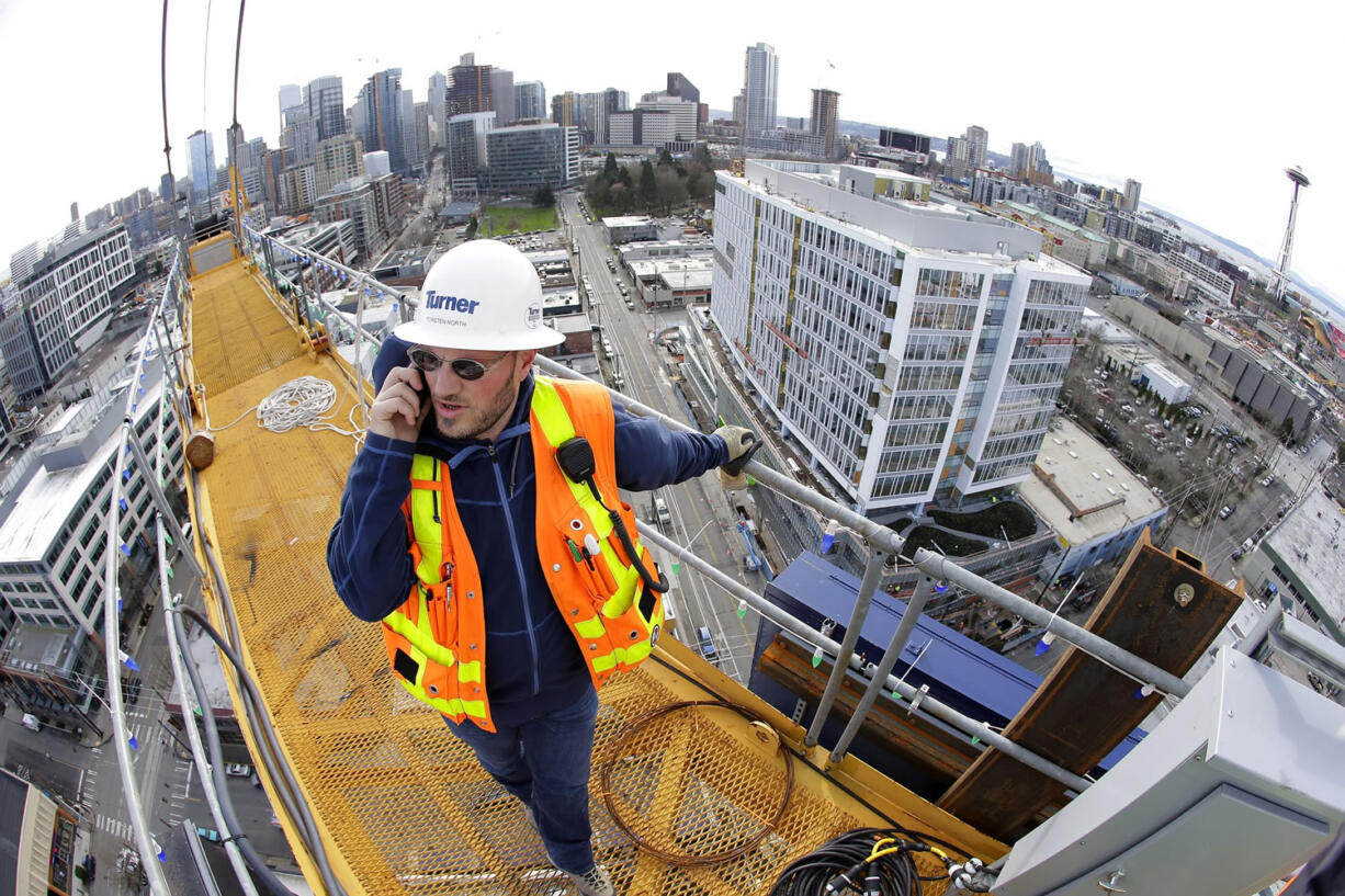 Torsten North, a project foreman for Turner Construction Company, talks on his phone in February at the top of a 238-foot high construction crane working on a new building in Seattle's South Lake Union neighborhood.