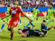 FC Dallas forward Tesho Akindele (13) reacts to Seattle Sounders FC goalkeeper Stefan Frei (24) stealing the ball during the first half of a MLS soccer game Saturday, March 28, 2015, in Frisco, Texas.