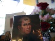 In this Jan. 27, 2015 image, a portrait of Franciscan missionary Junipero Serra can be seen in the gift shop of the Mission San Diego de Acala in San Diego. Pope Francis' announcement that he will canonize Serra is meeting resistance by some in California and beyond, as critics say he wiped out native populations, enslaved converts and spread disease.