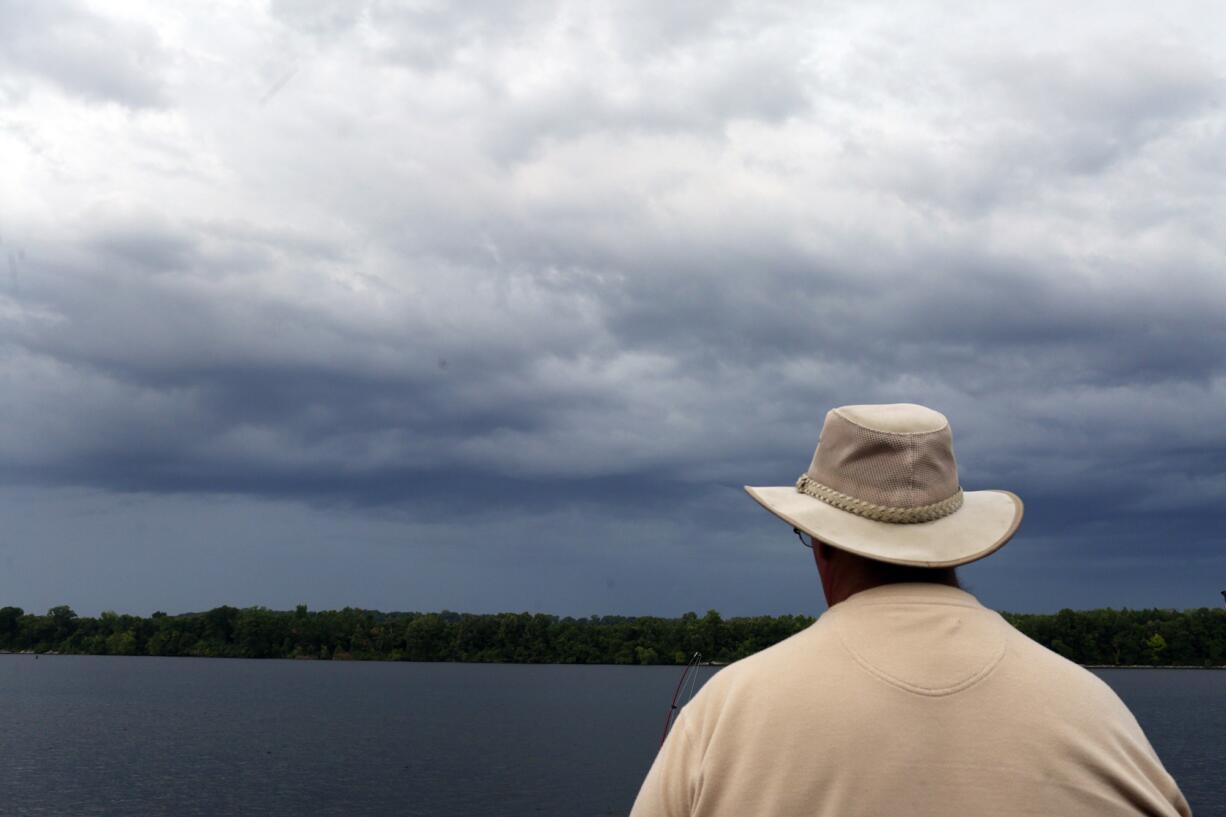 Marvin Hicks watches storm clouds Thursday as he fishes in Sheffield, Ala. Hicks was about to pack up due to lightning in the sky.