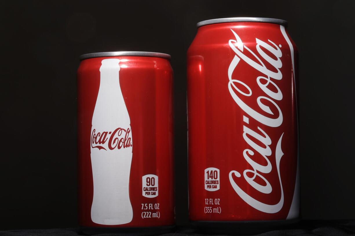 A 7.5-ounce can of Coca-cola, left, is next to a 12-ounce can for comparison.