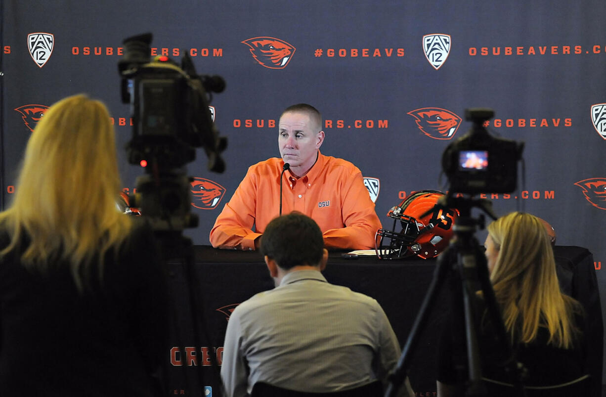 Oregon State head coach Gary Andersen, center, takes questions from the media while announcing his first signing class on national signing day Wednesday, Feb. 4, 2015, in Corvallis, Ore.