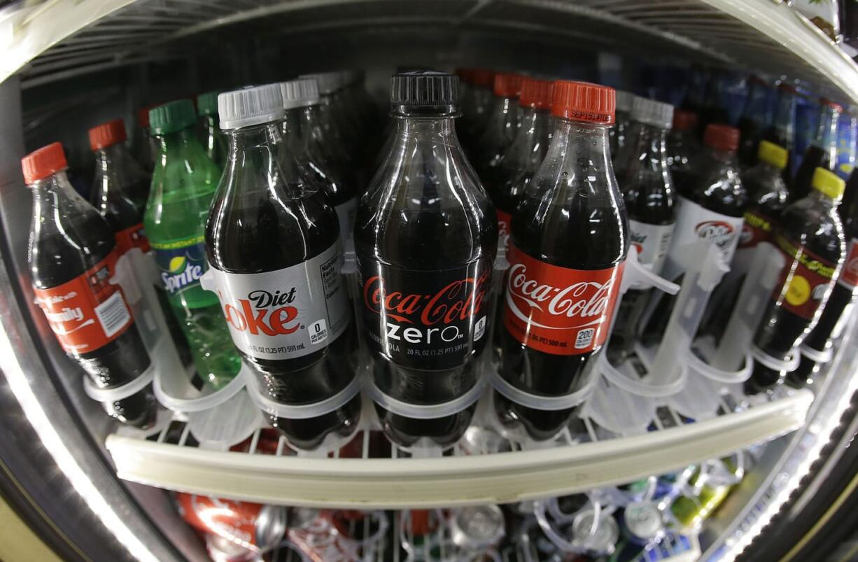 A shelf of diet and regular soft drinks in a refrigerator.