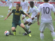 Seattle Sounders' Oniel Fisher (91) defends against Portland Timbers' Will Johnson (4) during the first half of an MLS Soccer game in Portland, Ore., Sunday June 28, 2015.