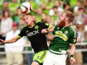 Seattle midfielder Andy Rose (5) heads the ball against Portland defender Nat Borchers Tuesday.