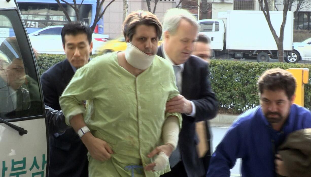 U.S. Ambassador to South Korea Mark Lippert, second from left, arrives Thursday at Severance hospital after undergoing surgery to his face and arms in Seoul, South Korea. Police on Friday investigated the motive of an anti-U.S. activist they say slashed Lippert, as questions turned to whether security was neglected.