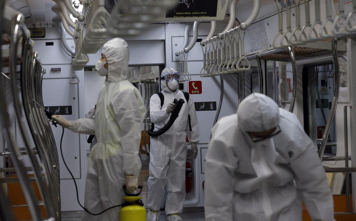 Workers wearing protective gear spray antiseptic solution in a subway car amid rising public concerns over the spread of MERS, Middle East Respiratory Syndrome, virus at the subway car depot in Goyang, South Korea, on Tuesday.