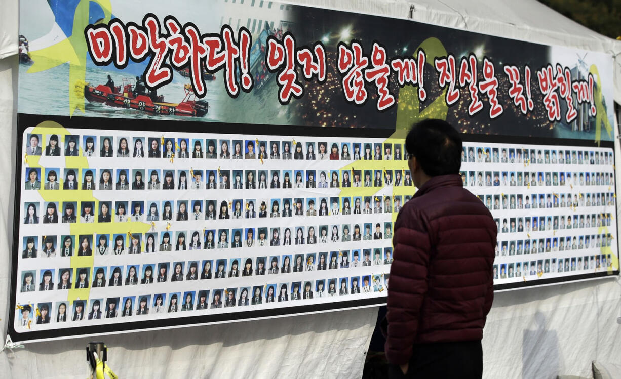 A man looks at portraits Tuesday of victims aboard the ferry Sewol that sank in the water off the southern coast, in Seoul, South Korea.