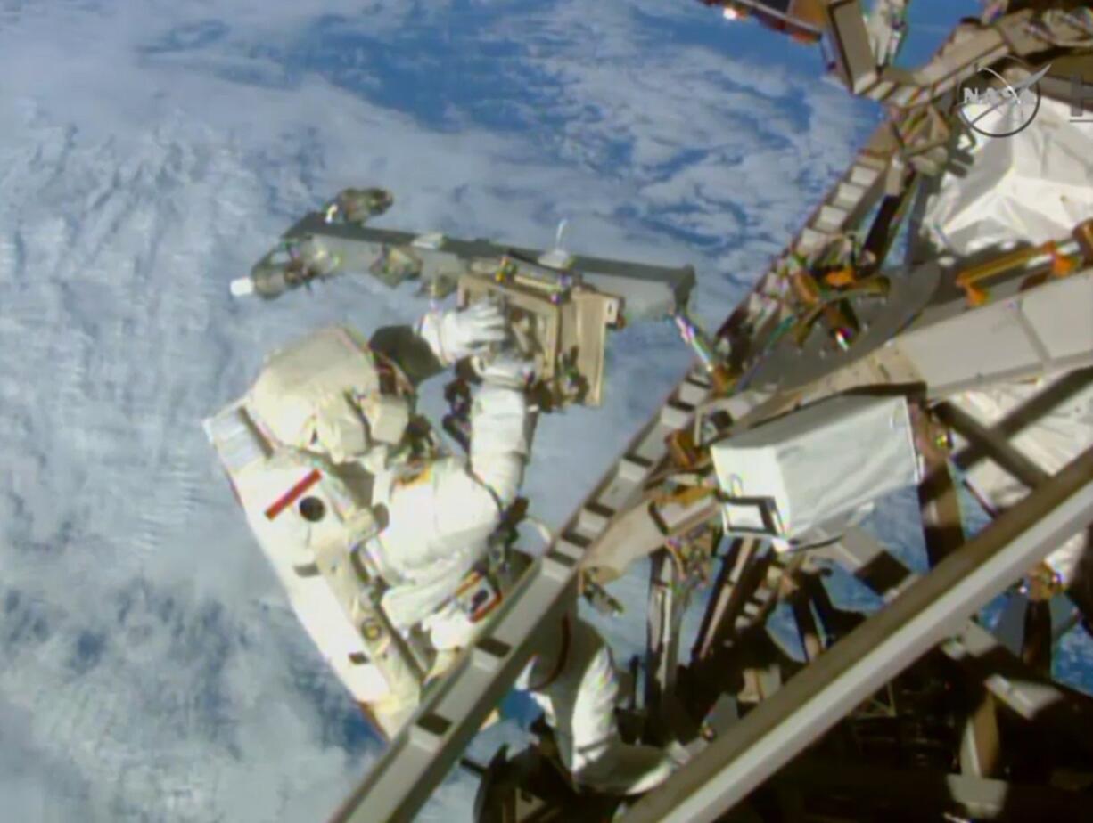 NASA-TV
American astronaut Terry Virts installs an antenna and boom Sunday during the third spacewalk outside the International Space Station. Astronauts Virts and Butch Wilmore had 400 more feet of power and data cable, as well as two antennas, to install Sunday.