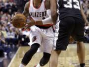 Portland Trail Blazers guard Damian Lillard, left. drives around San Antonio Spurs center Boris Diaw during the first half on Monday, Dec. 15, 2014.