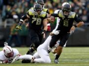 Oregon quarterback Marcus Mariota (8) tries to get away from the defender during the second quarter against Stanford on Saturday, Nov. 1, 2014.