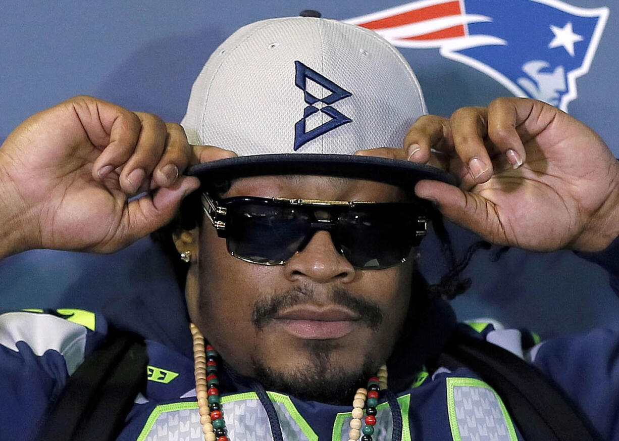 Seattle Seahawks' Marshawn Lynch adjusts his cap during an interview Thursday, Jan. 29, 2015, in Phoenix.